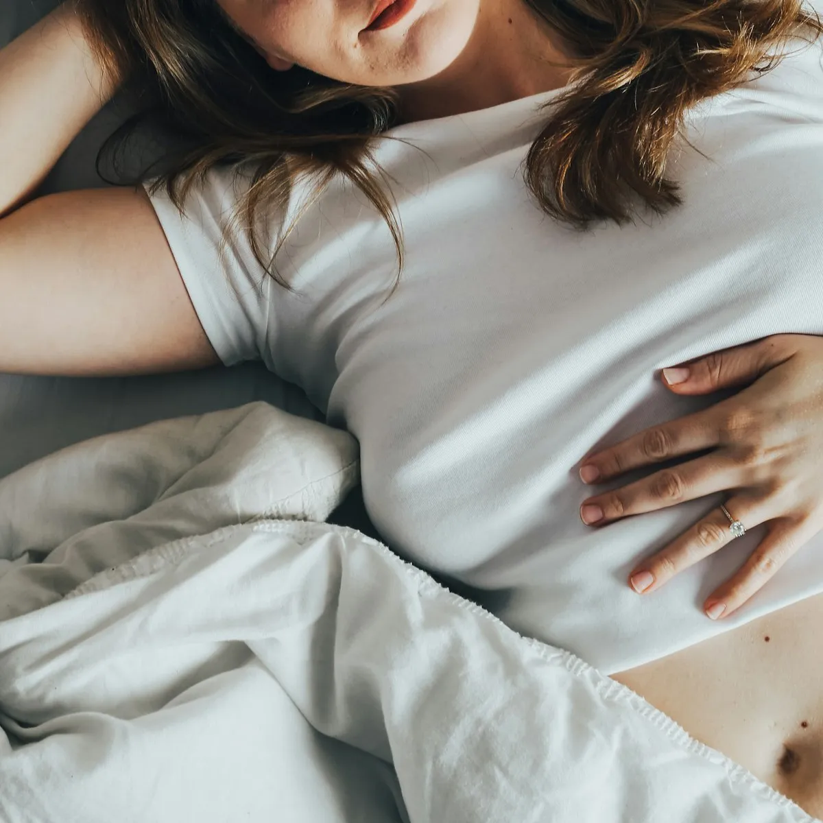 Person resting in bed recovering from food poisoning at home in Los Angeles