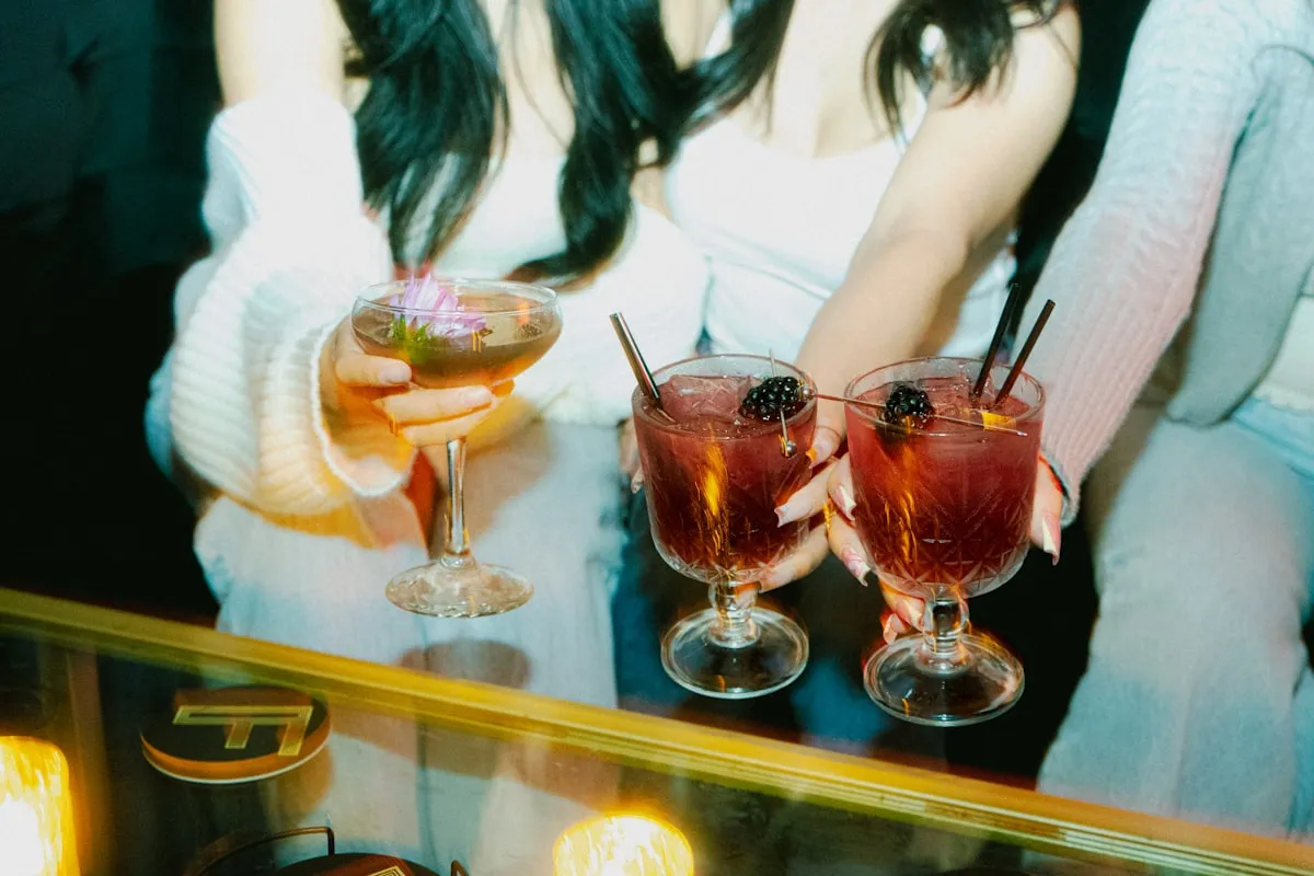 Friends holding cocktails at a rooftop bar in Los Angeles