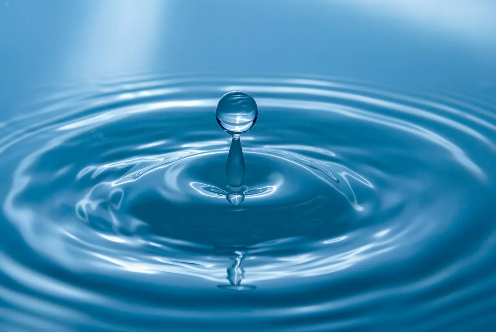 Close-up of a water droplet ripple representing hydration, fluid therapy, and IV drip add-on for extra hydration.