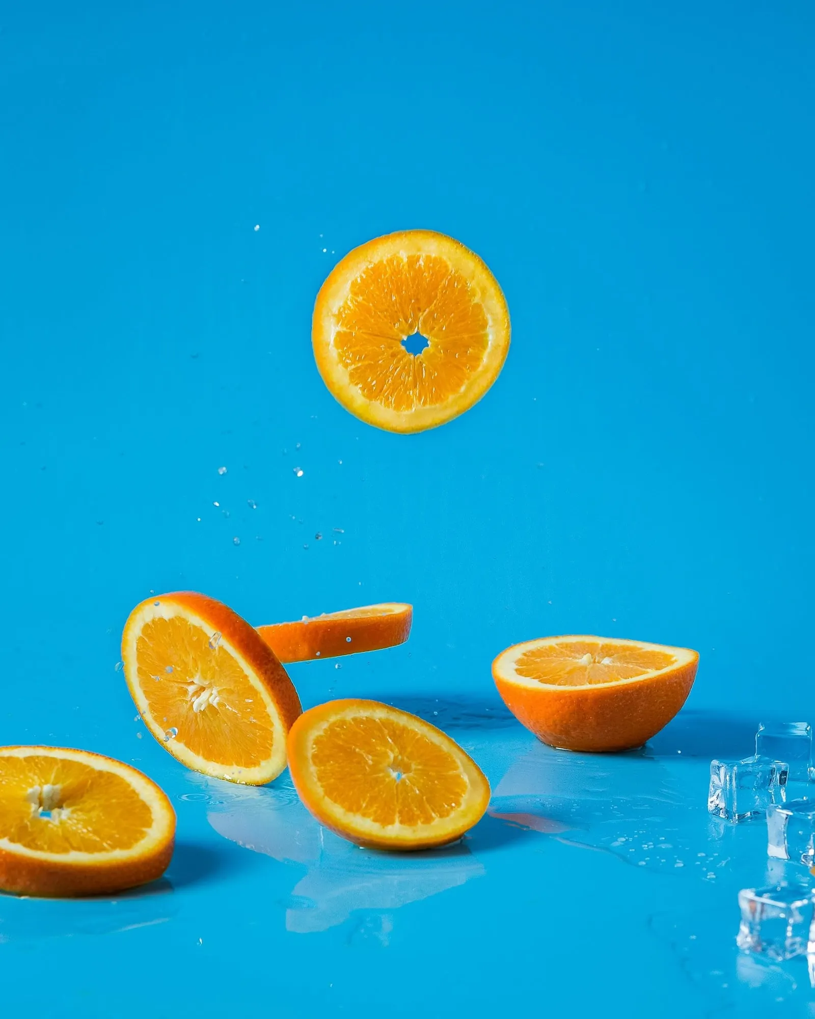 Sliced oranges and water drops symbolizing Vitamin C and hydration benefits from IV therapy add-ons.